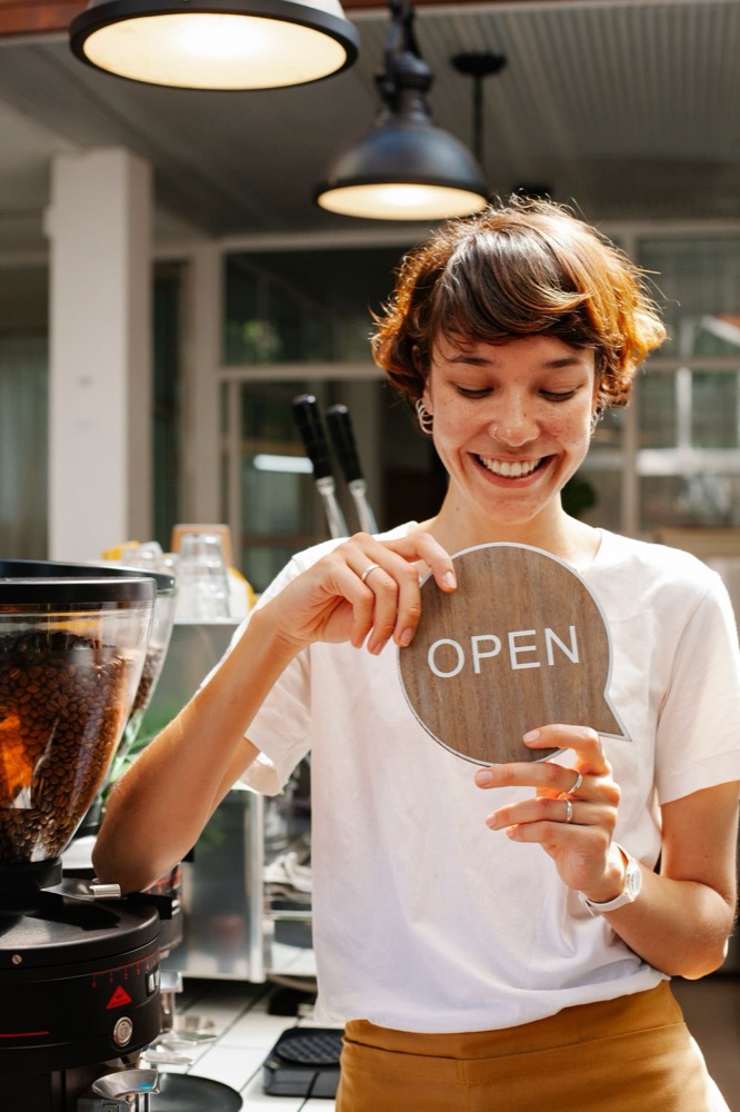 Cafe owner holding an open sign